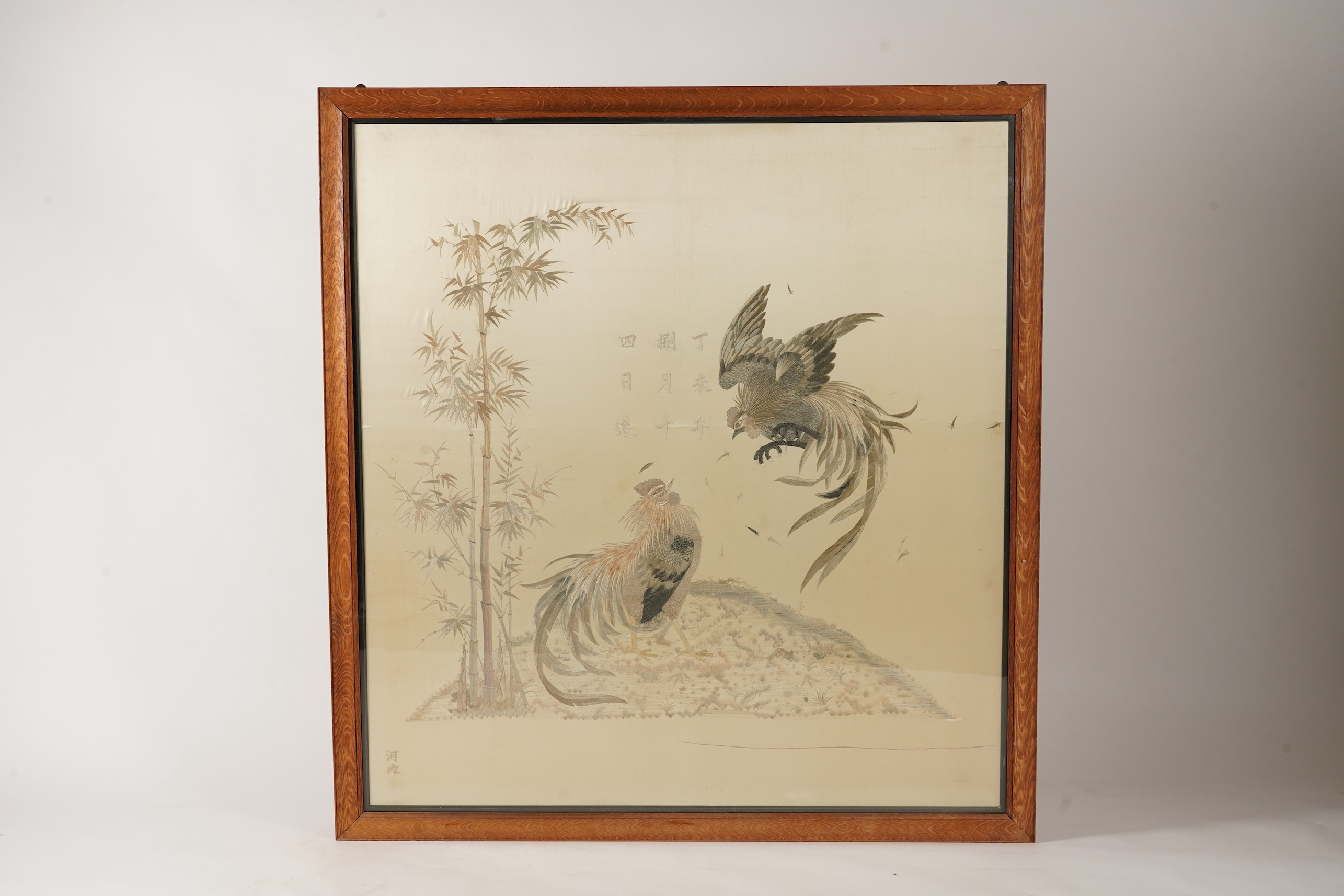 A large Japanese embroidered ‘fighting cockerels’ panel, Meiji period, signed Kawauchi, dated August 14, 1907